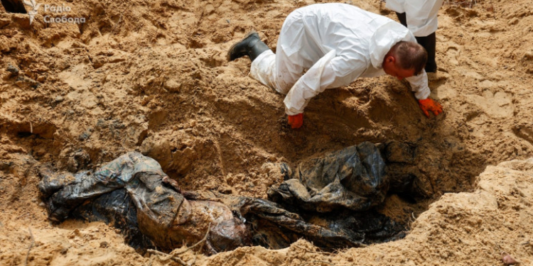 „Tatăl era născut în 1988, soția în 1991, fiica în 2016”. Greaua misiune a ucrainenilor care sapă în cimitirul ascuns de ruși în Izium