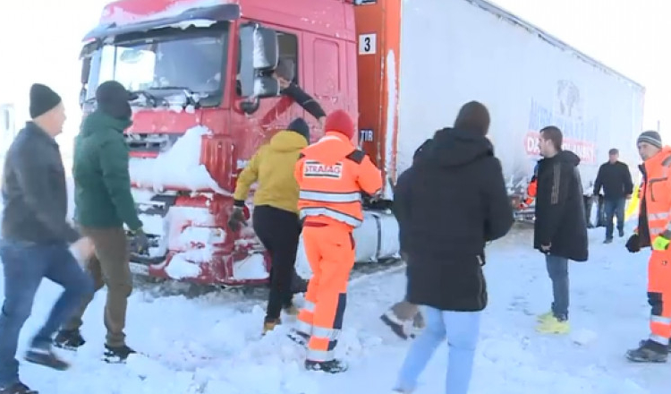 Misiune imposibilă în Constanța. Zeci de șoferi încearcă cu lopeți și cu mâinile goale să scoată din zăpadă un TIR blocat de ieri